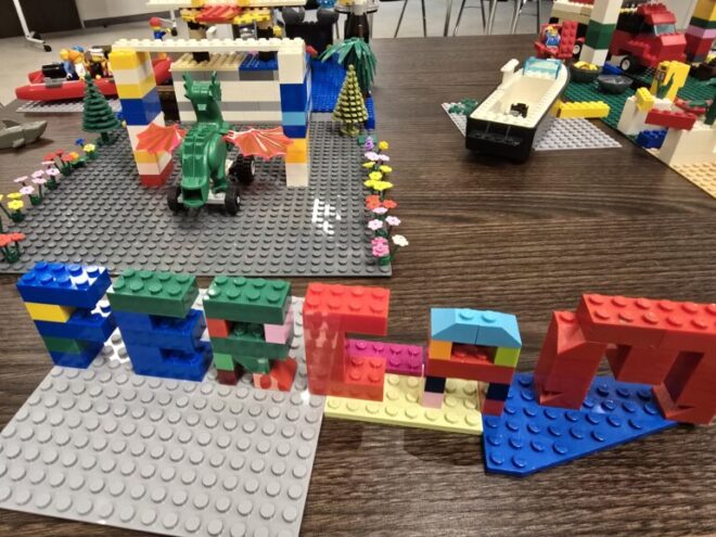Objekte aus Lego gebaut auf einem Tisch. Ergebnisse einer Teamklausur zum Thema "Zukunft der Organisation".
